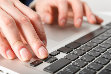 Close-up of hands businessman working at computer in office.