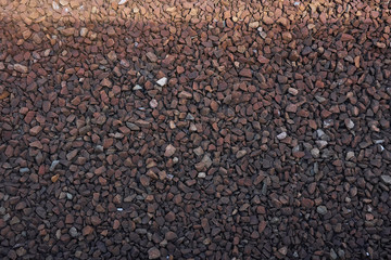 Brown gravel, stone in shadow