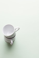 cups stacked on light green background