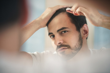 Young Man Applying Lotion For Alopecia And Hair Loss Treatment