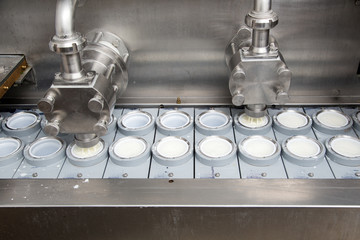 Final Stage Of Production Yogurt-Filling Yogurt Into Plastic Glasses In Modern Dairy