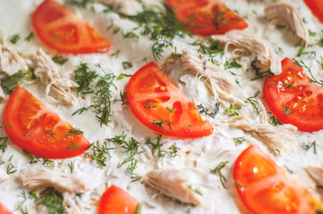 Pizza ingredients are closeup. Tomatoes, chicken, cheese, dill. Blurred background
