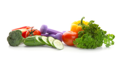 Fresh vegetables and dumbbells on white background. Diet food