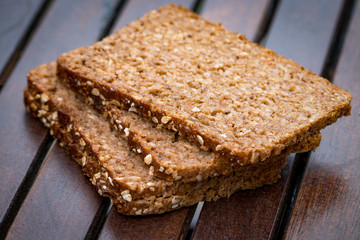 Fresh baked bread or bun with sesame on wood background
