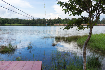 Young woman crossing a lake in zip line