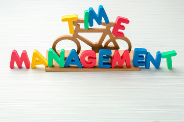 Small bicycle and phrase "Time management" composed from letters on table