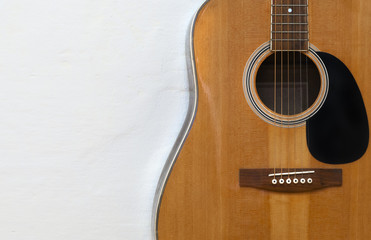 Fototapeta premium Acoustic guitar on a textured white wall