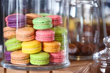  Lekkere kleurrijke macarons onder glazen koepel op tafel © Pixel-Shot