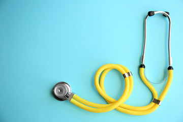 New stethoscope on color background, top view