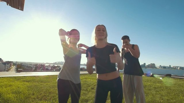 Team of young friends cheerleaders workout outdoors having fun, girl showing thumbs up at summer day