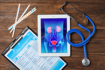 Flat lay composition with tablet, stethoscope and test form on wooden background. Urology concept - obrazy, fototapety, plakaty