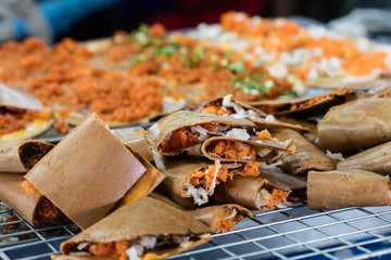 Kanom Bueang is an ancient Thai dessert known as crispy pancakes in English. It is a popular form of street food in Thailand. filled with coconut cream,  shredded coconut, chopped scallions and yolk