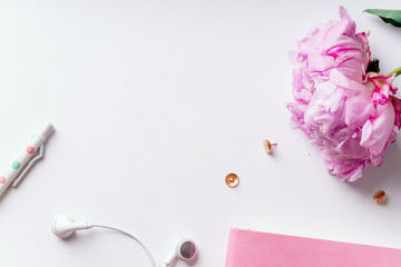 Feminine workspace with pink peons on white background with copy space