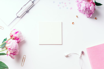 Feminine workspace with pink peons on white background with copy space