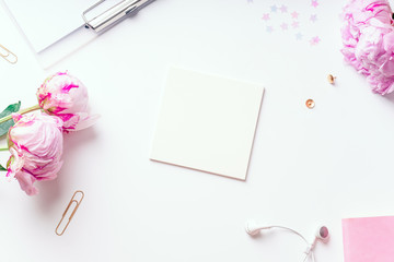 Feminine workspace with pink peons on white background with copy space