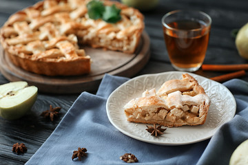 Plate with piece of tasty homemade apple pie on wooden table
