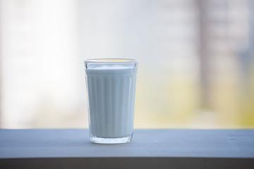 The glass is filled with milk. On open air. Summer sunny day. Theme of a healthy lifestyle