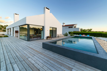 Modern house with garden swimming pool and wooden deck