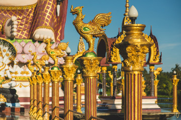 Row of golden rooster statues in buddhist temple