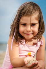 little girl is playing on the sand at the beach in the summer