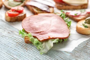 Toasted bread with ham on wooden table