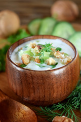 Cold soup Tarator with kefir in a wooden bowl. Bulgarian cuisine meal