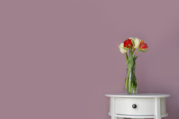 Vase with beautiful tulips on color background