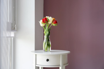 Vase with beautiful tulips on table indoors