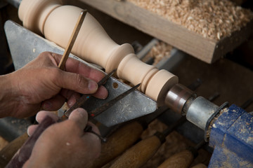 Carpenter turning hard wood on a lathe  hands close up