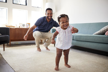 Baby Daughter Dancing With Father In Lounge At Home - Powered by Adobe