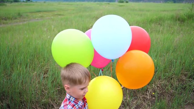 Happy little baby, fun playing with balloons. Outdoor recreation. Celebration and fun.