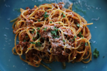 spaghetti Bolognese with minced beef and tomato sauce garnished with parmesan cheese and basil , Italian food top view