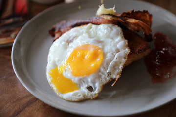 Breakfast french toast with bacon egg and cheese with jam on wood table background