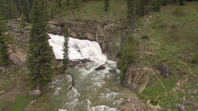 Aerial view of waterfall in the Wyoming landscape flowing it downstream.