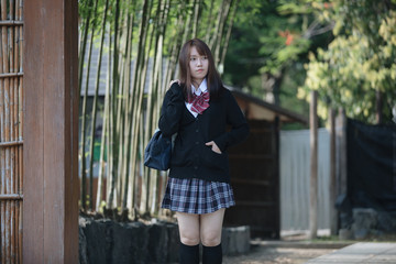 Portrait Asian japanese school girl costume looking in japanese garden