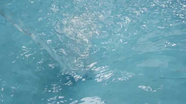 slow motion clean water pouring in blue pool