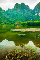 Obraz premium Lake reflection with mountains, Trang An Scenic Landscape in Ninh Binh in Vietnam