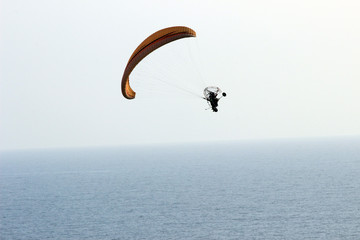 Persona en parapente sobre el océano