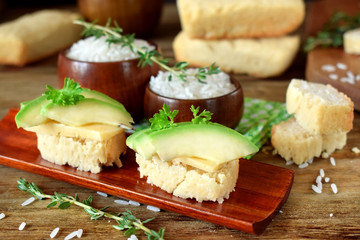 Sandwiches with cheese and avocado slices on pieces of rice gluten free bread