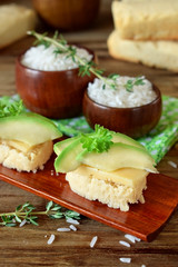 Sandwiches with cheese and avocado slices on pieces of rice gluten free bread