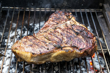 Whole T-Bone steak cooking on grill