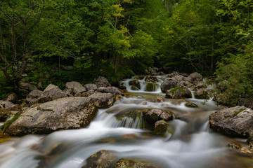 Naklejka na ściany i meble Tranquillo flusso d'acqua delle piccole cascate vicine alla sorgente del fiume Isonzo, ne Parco nazionale del Triglav, Slovenia
