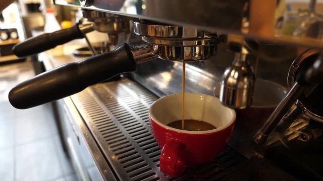 Barista makes espresso coffee cup on the machine servicing an order in cafe bistro