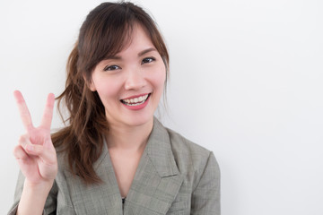 asian business woman pointing two fingers; portrait of positive happy smiling asian businesswoman...