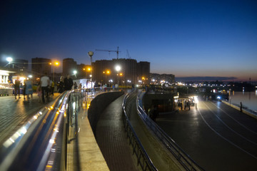 Fototapeta na wymiar Blurred photo, city embankment. Beautiful lights on the waterfront.