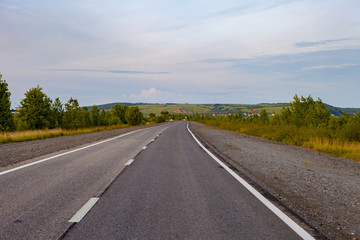 An empty road leading to the village on the hills.