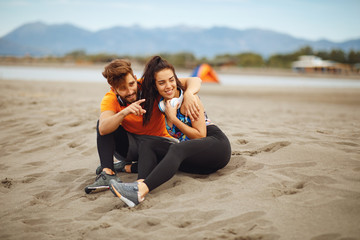 Young couple enjoying the beach after workout