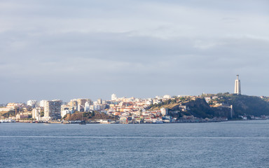 The view across the Tagus River towards the city of Almada, Portugal. In the background can be seen the Christ the King Sanctuary.