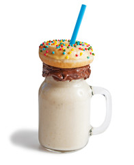 Banana milkshake in a glass jar (mason jar) with donut, isolated on white background.