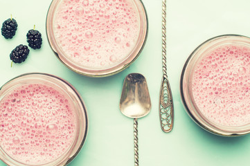 Smoothies of mulberries and mint in glass jars